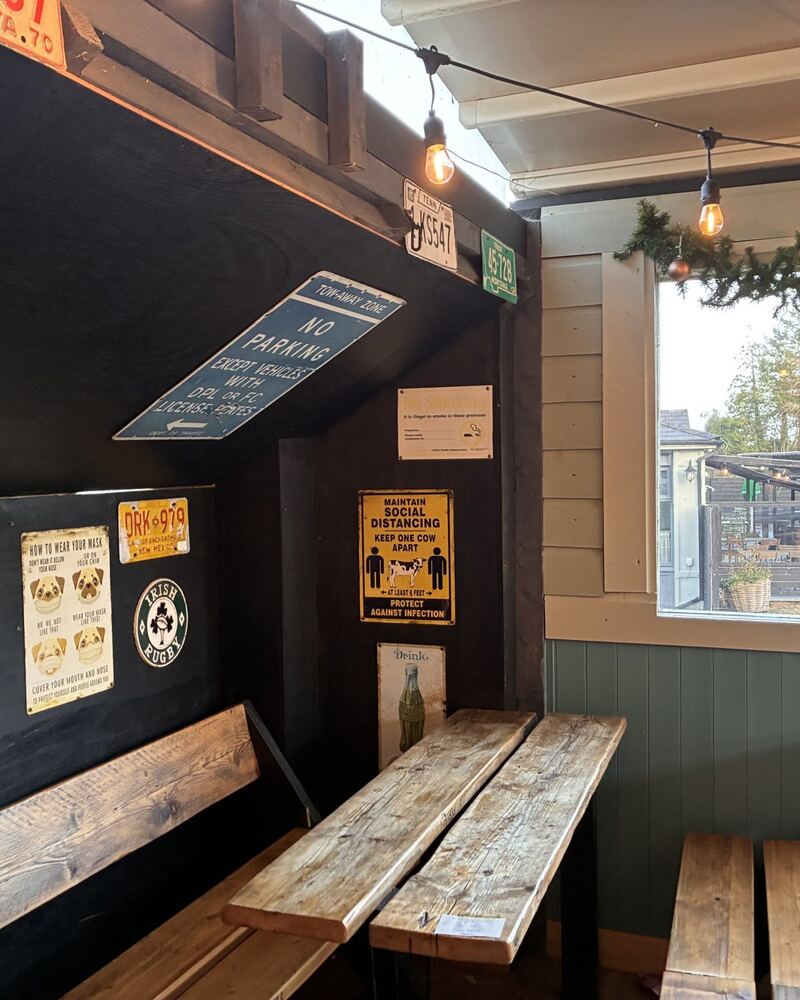 Timber benches and licence plates on a dark wall in the dining room