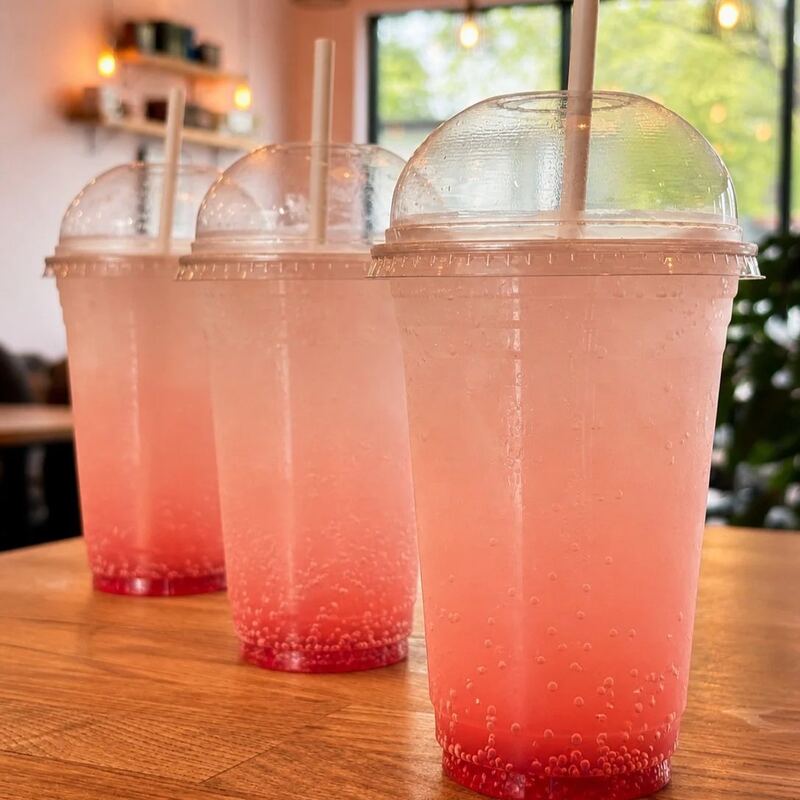 Three pink lemonade drinks on a table in the café