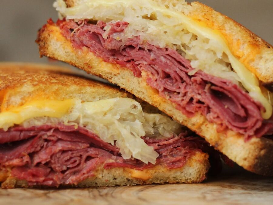 A grilled Reuben sandwich, halved